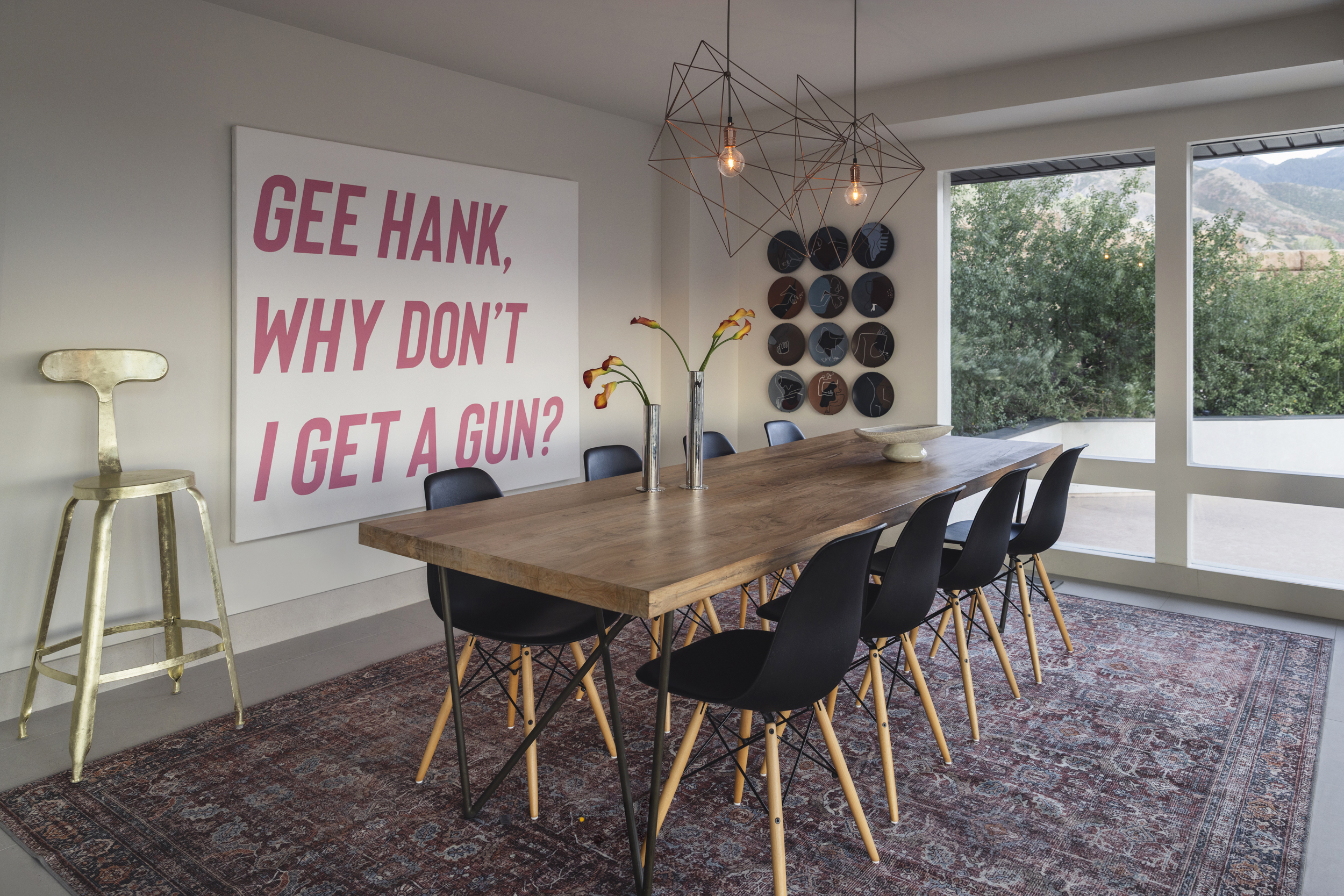 Dining room with a long wood table, art and mountain views