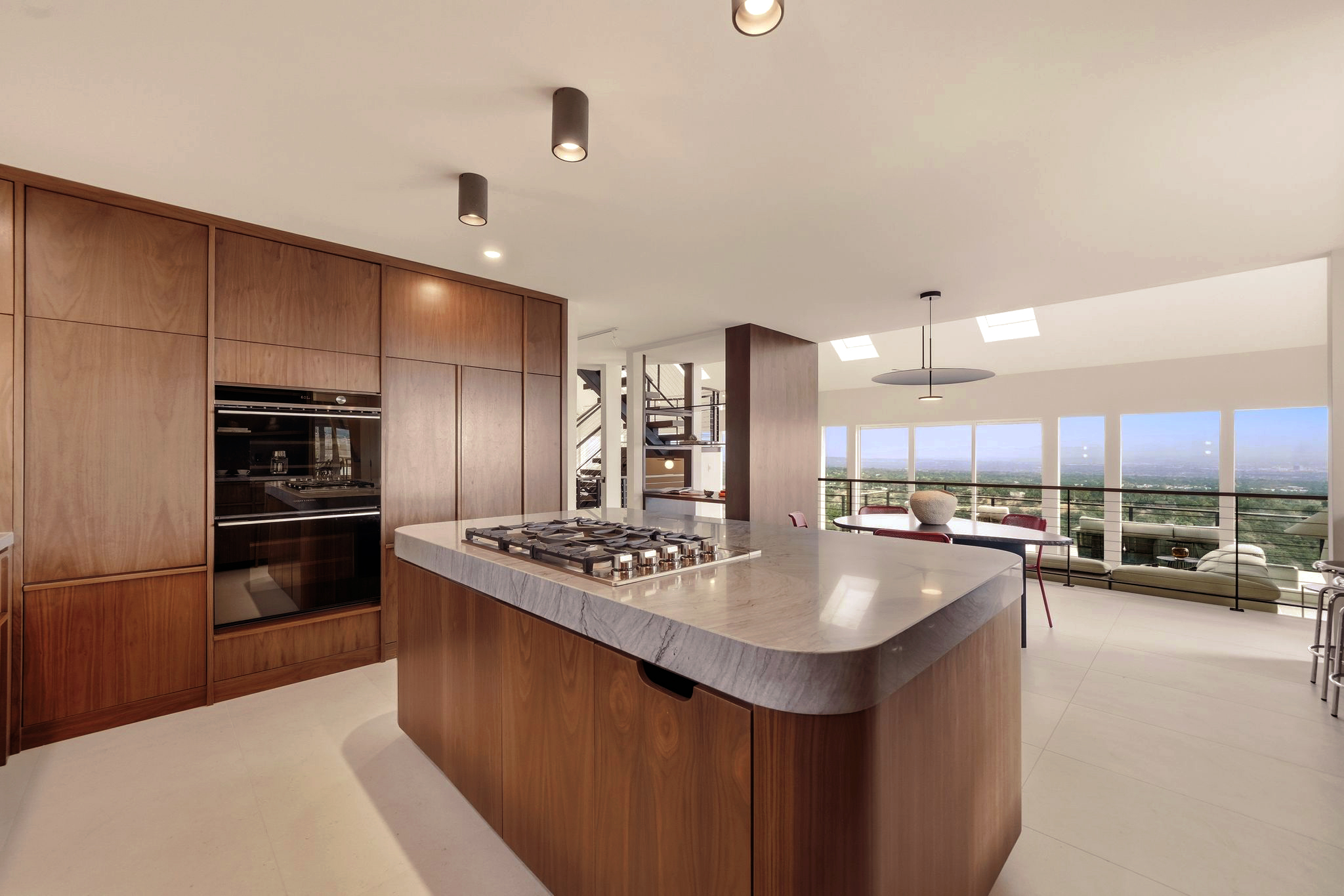 Modern kitchen with warm cabinetry, large island and city view