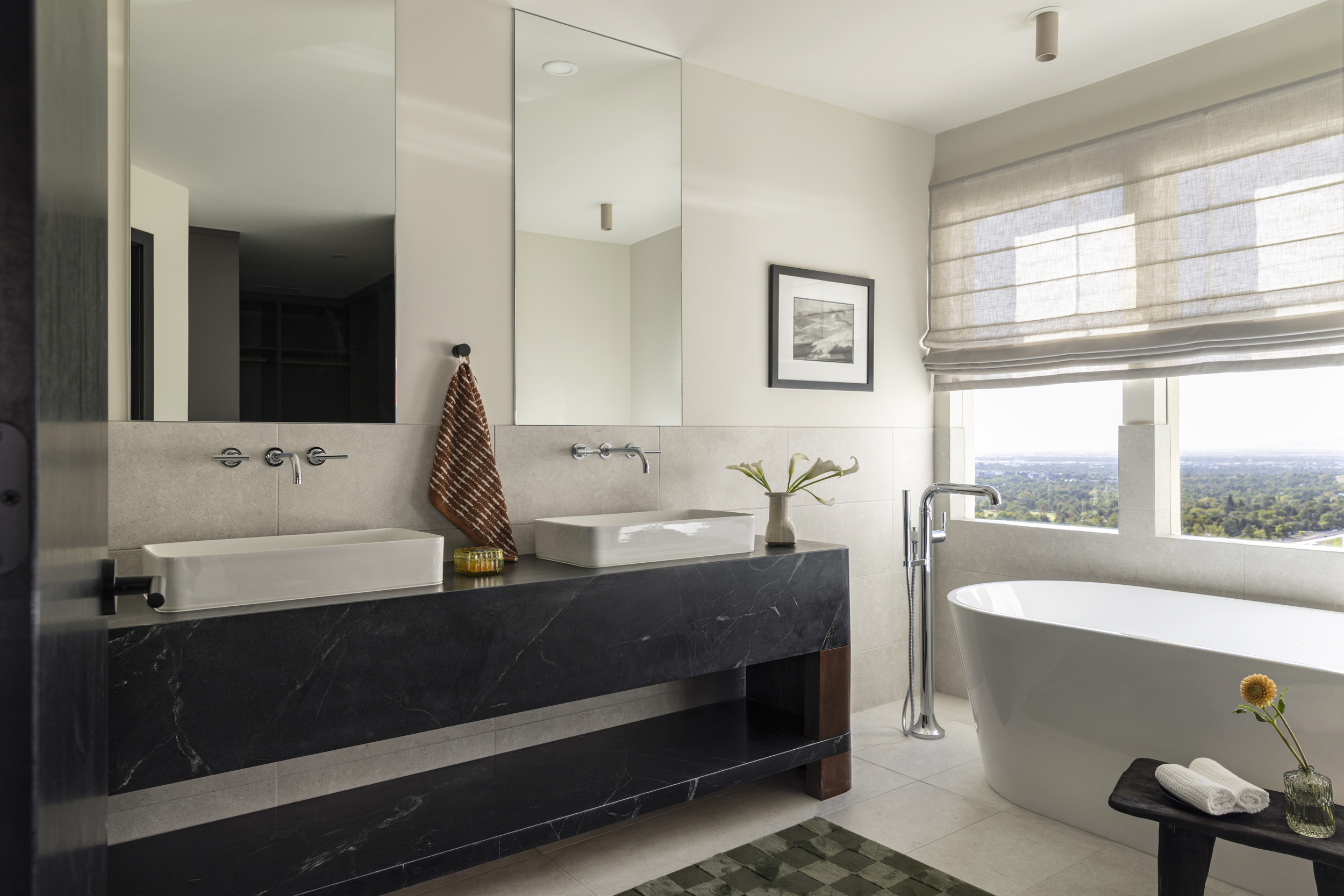 Primary spa bathroom with dual vanities, soaking tub and mountain view