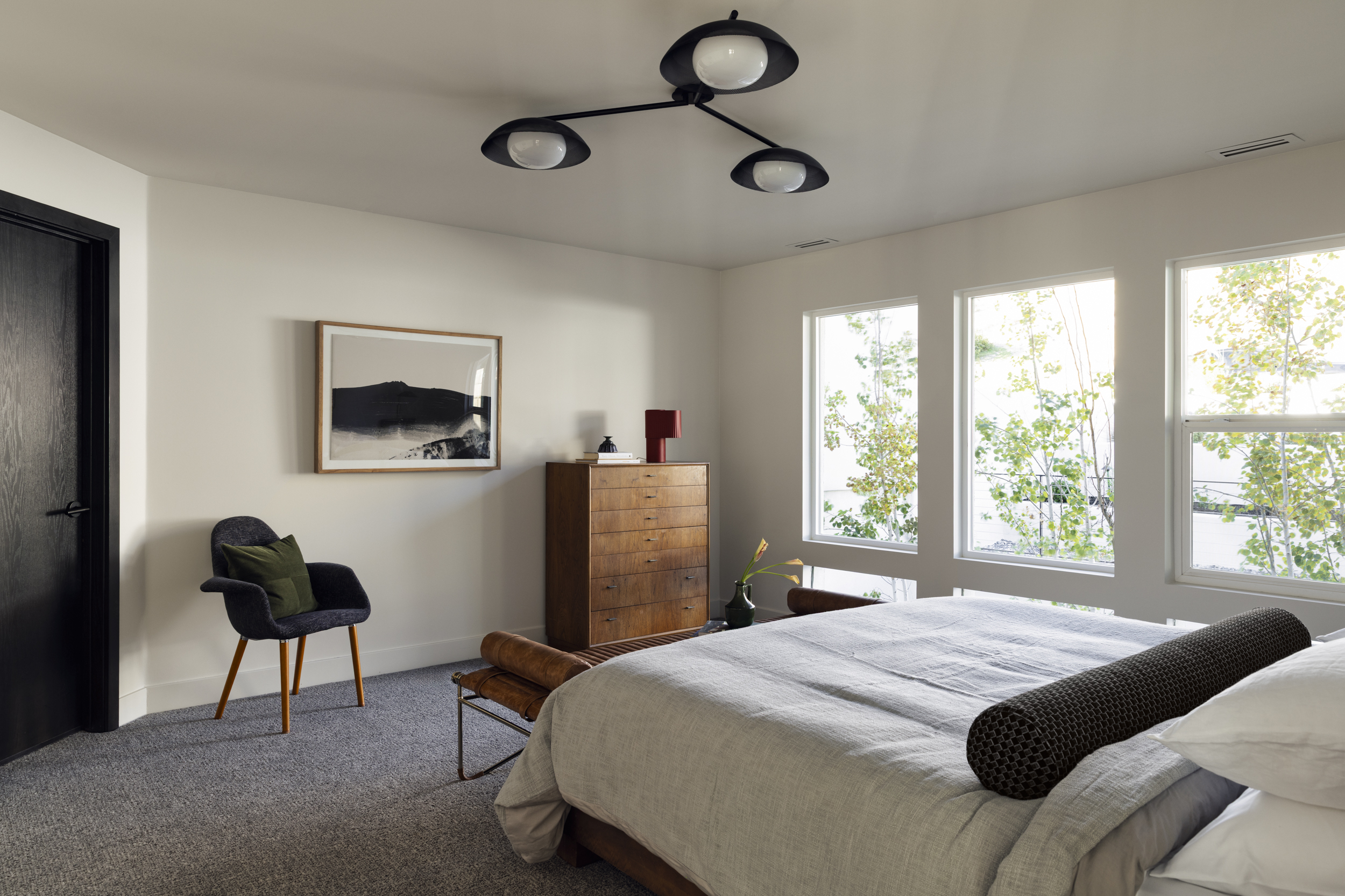 Primary bedroom with windows, tailored furnishings and mountain light